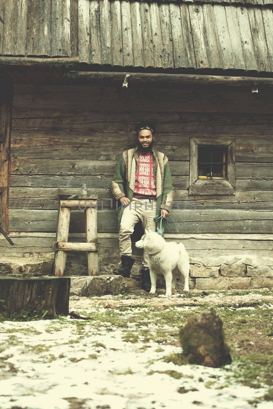 hipster with dog in front of wooden house by dotshock