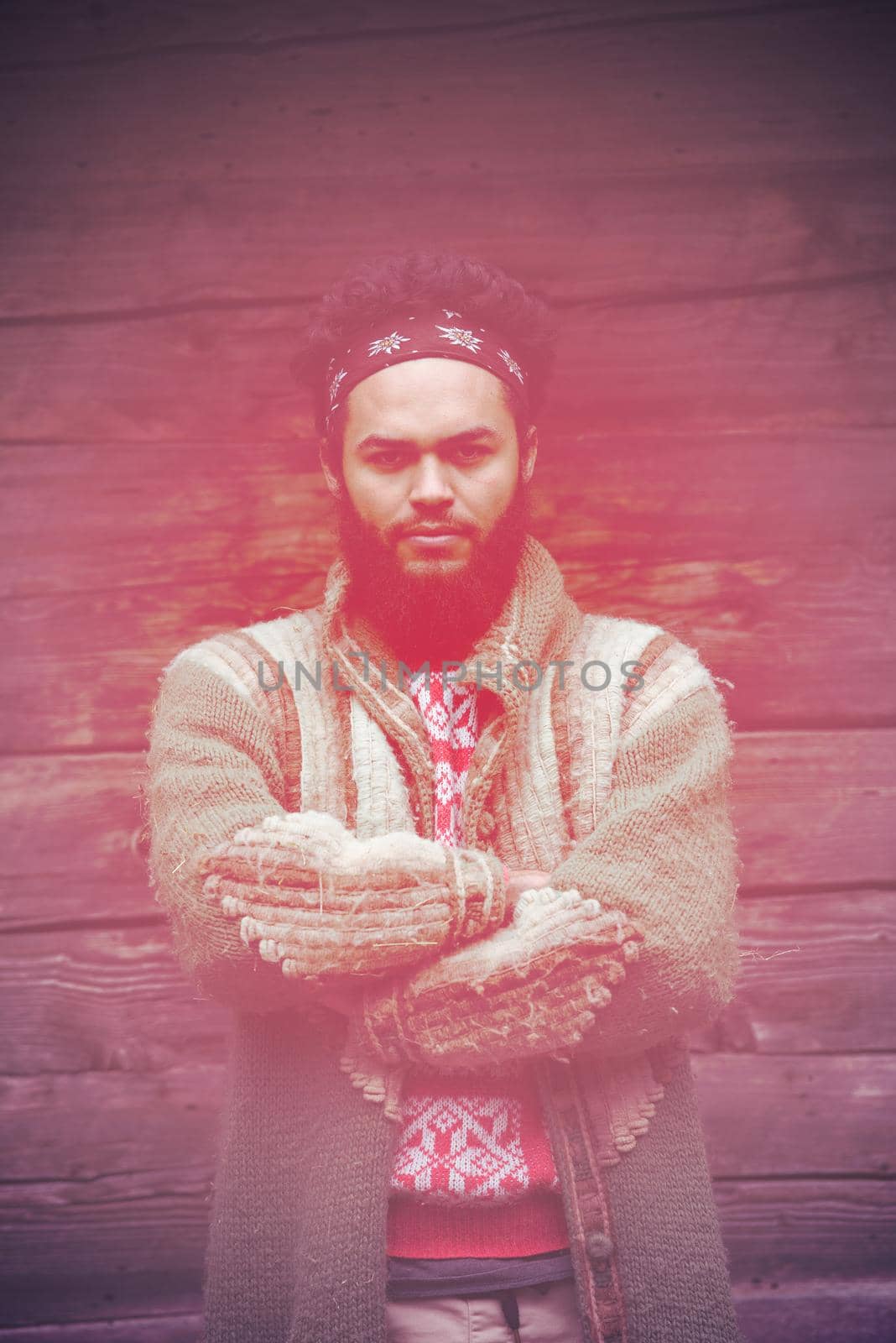 portrait of young hipster,  man with beard in front of old vintage wooden house