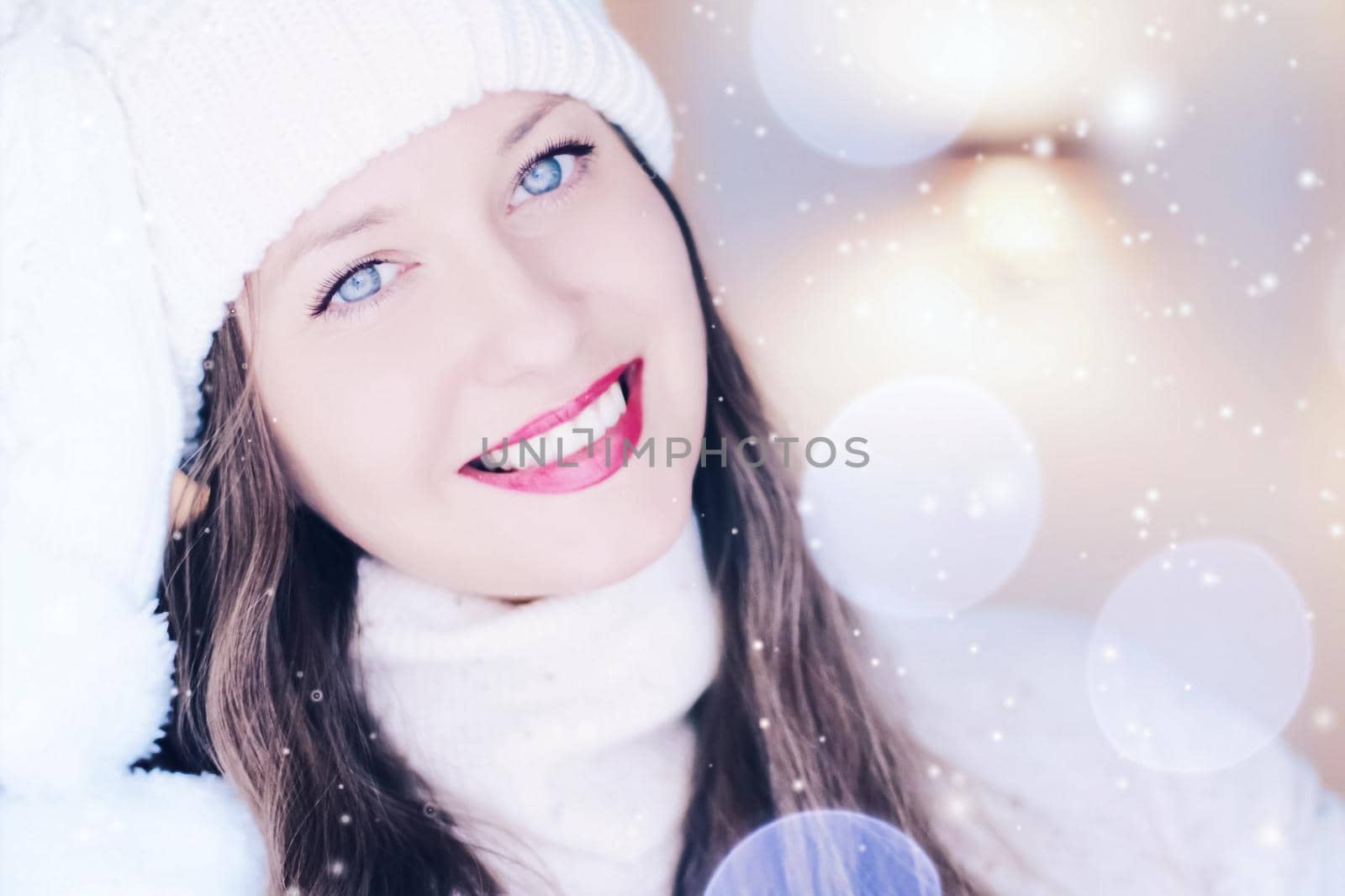 Christmas, people and winter holiday concept. Happy smiling woman wearing white knitted hat as closeup face xmas portrait, snow glitter and bokeh effect.