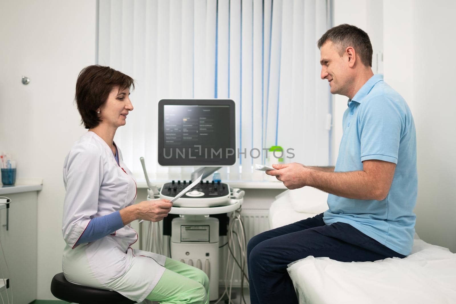 Doctor cardiologist in the office of ultrasound diagnostics with the patient examines medical tests during a health check-up in a modern clinic. Medical consultation. healthcare, medical service.