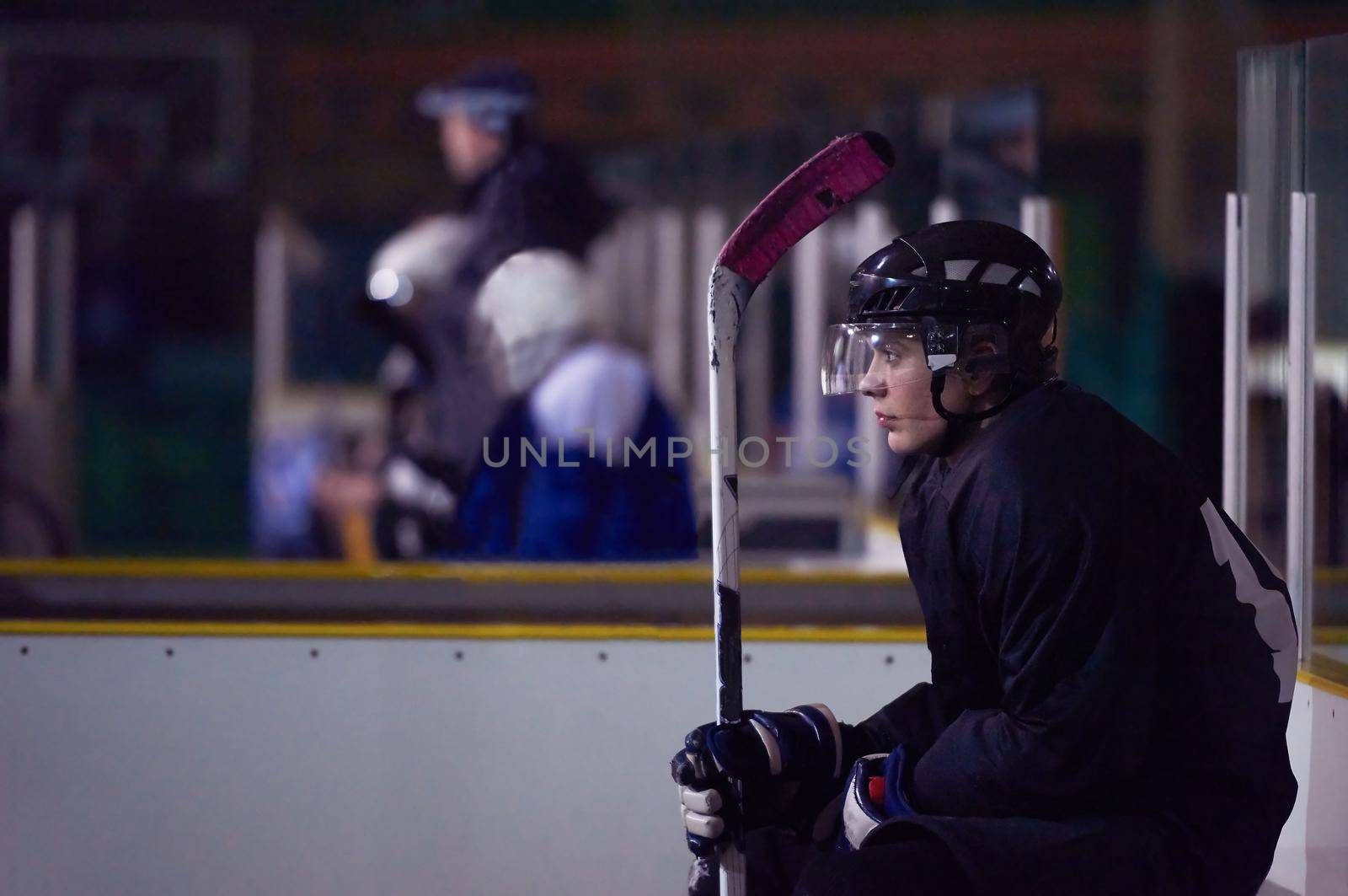 young ice hockey player portrait on training in black background