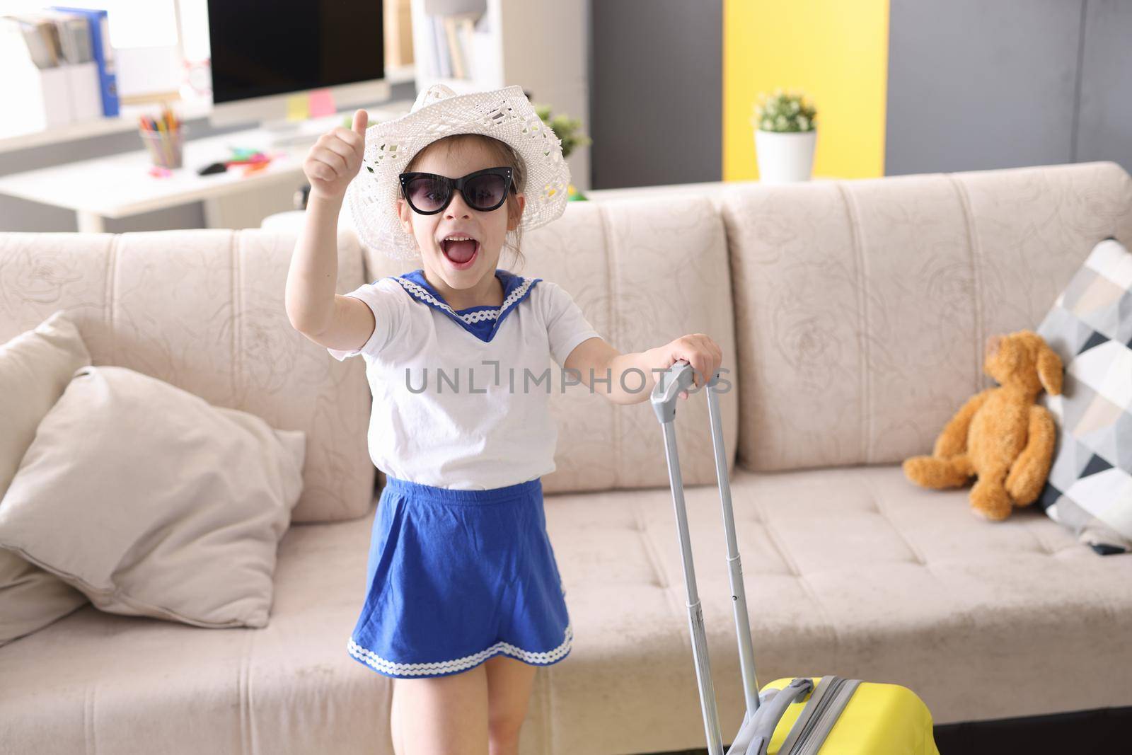 Little girl in sunglasses with suitcase. Kids vacation concept