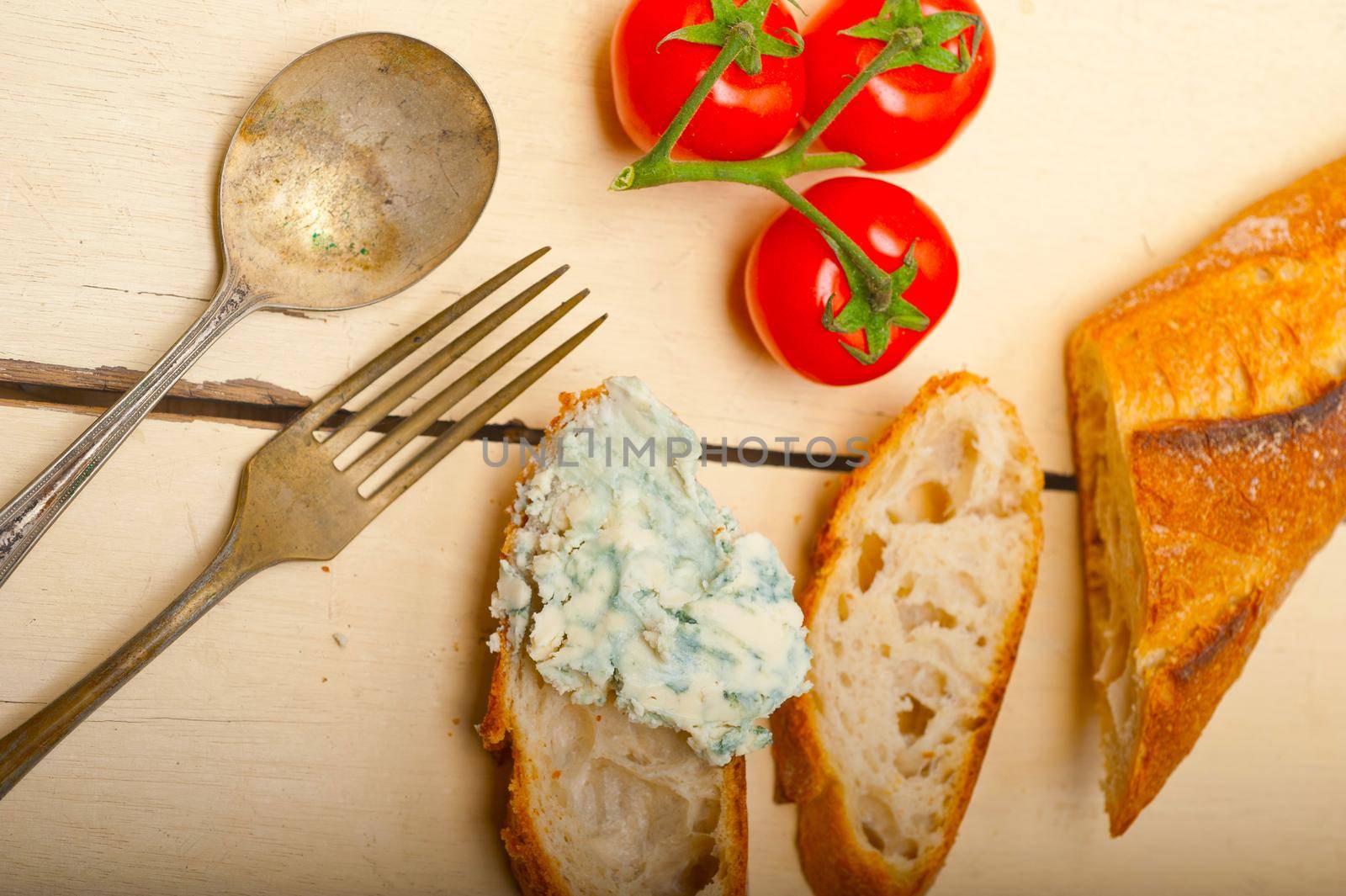 fresh blue cheese spread ove french baguette with cherry tomatoes on side