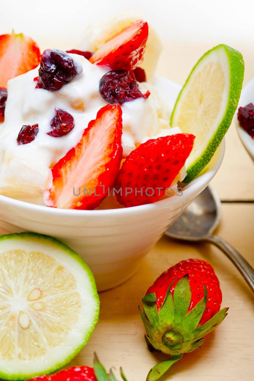 fruit and yogurt salad healthy breakfast over white wood table