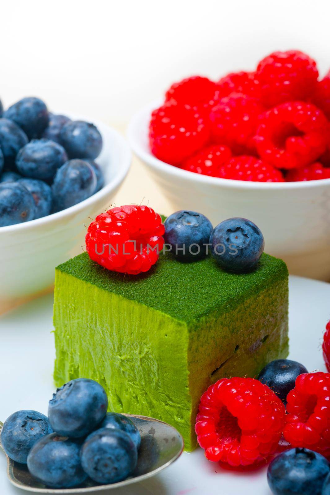 green tea matcha mousse cake with raspberries and blueberries on top