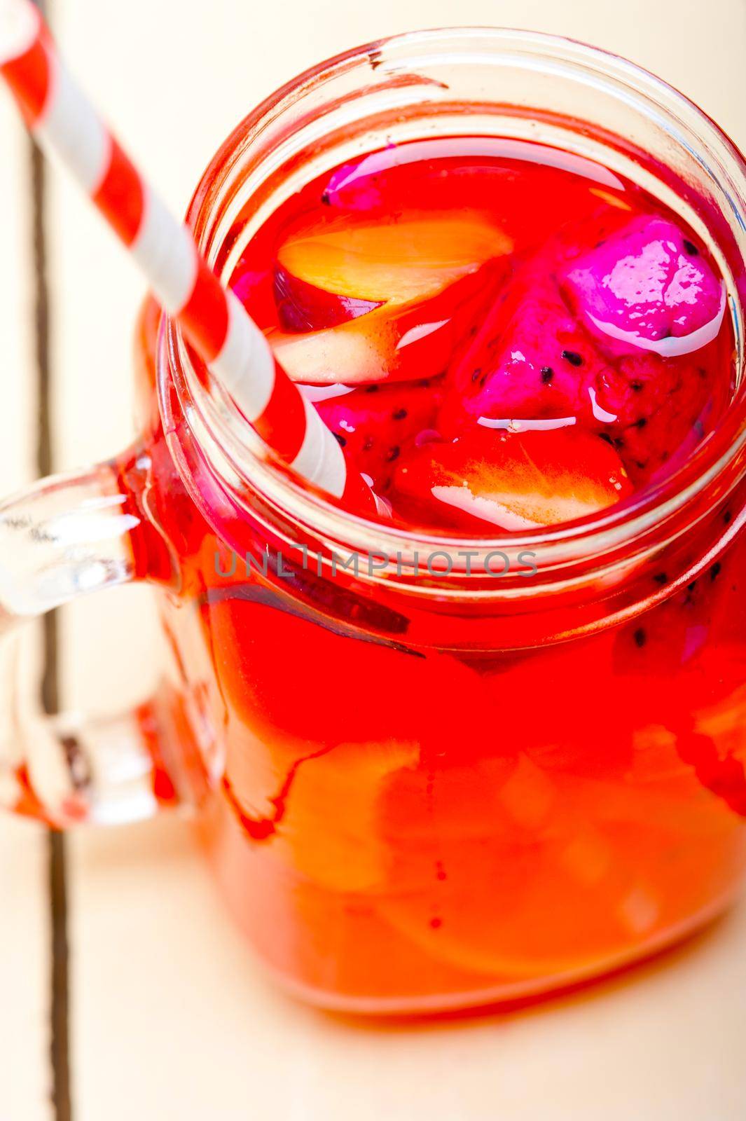 fresh fruit punch refreshing summer  drink over white rustic wood table