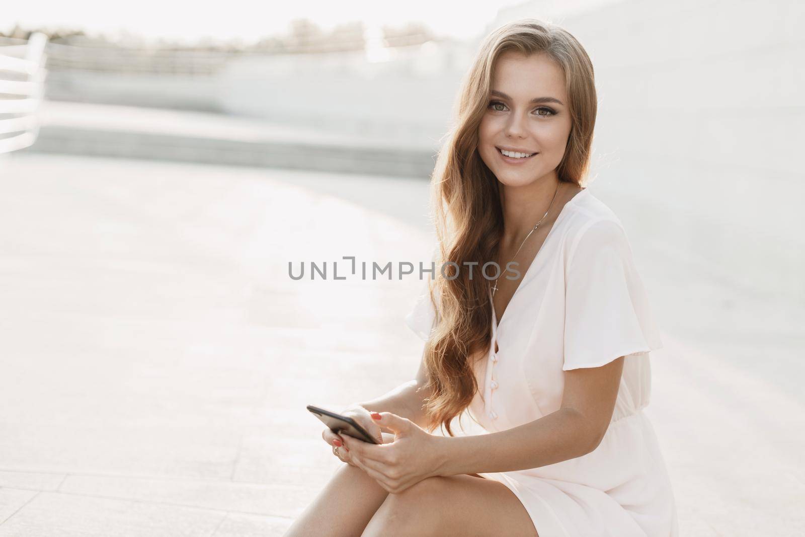 Happy young pretty woman with phone by splash