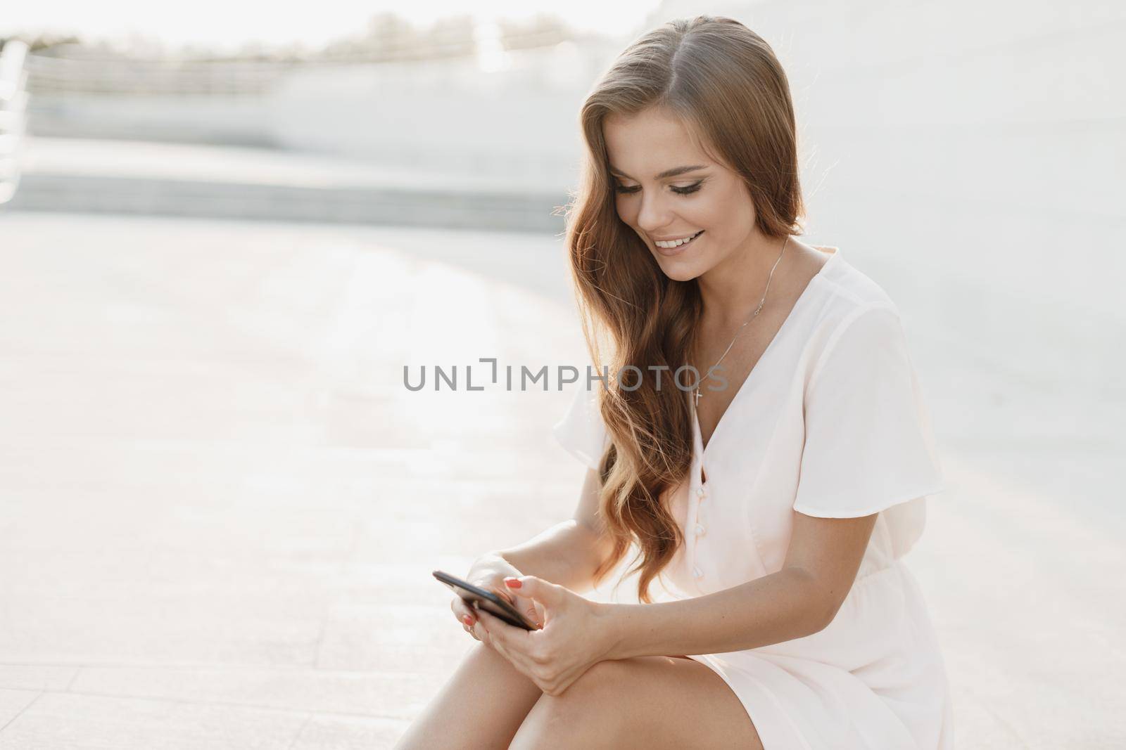 Happy young pretty woman with phone by splash