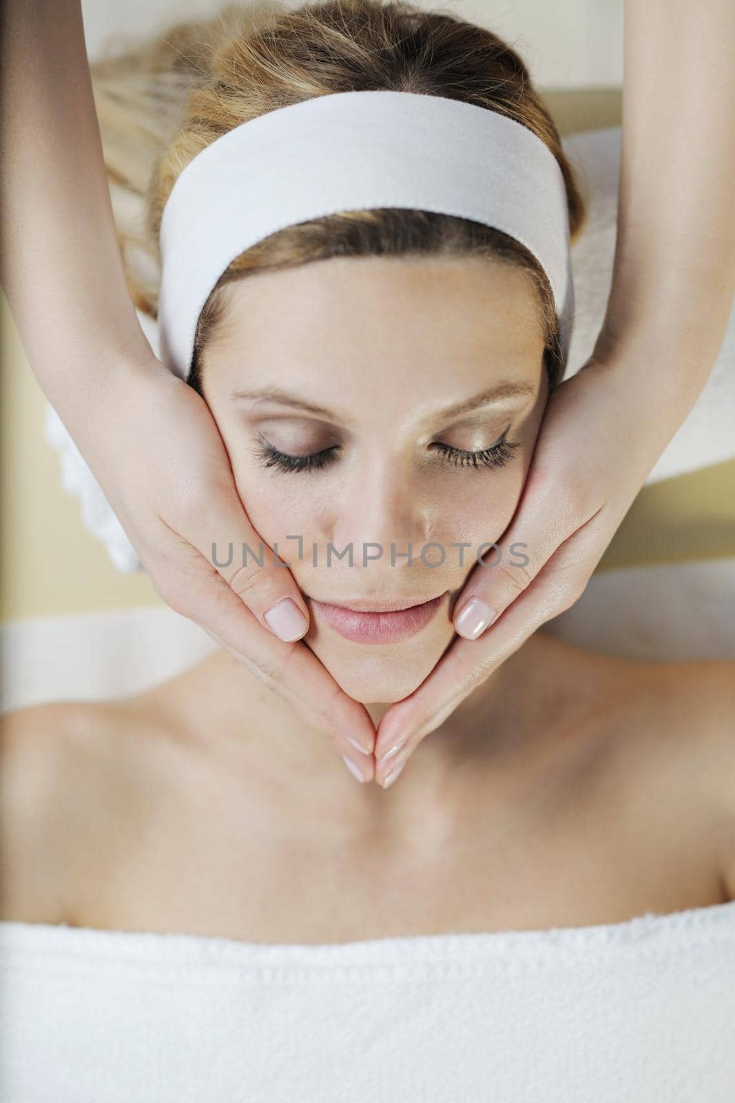 Beautiful young woman in spaand wellness. Face back and  stone massage