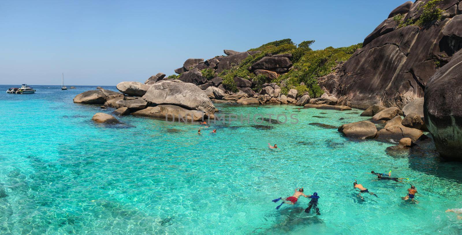 Similan Islands, Thailand - February 23, 2016:  Tourists snorkeling, swimming and enjoying crystal clear water in Similan Islands during guided tour on a sunny day. by Ivanko