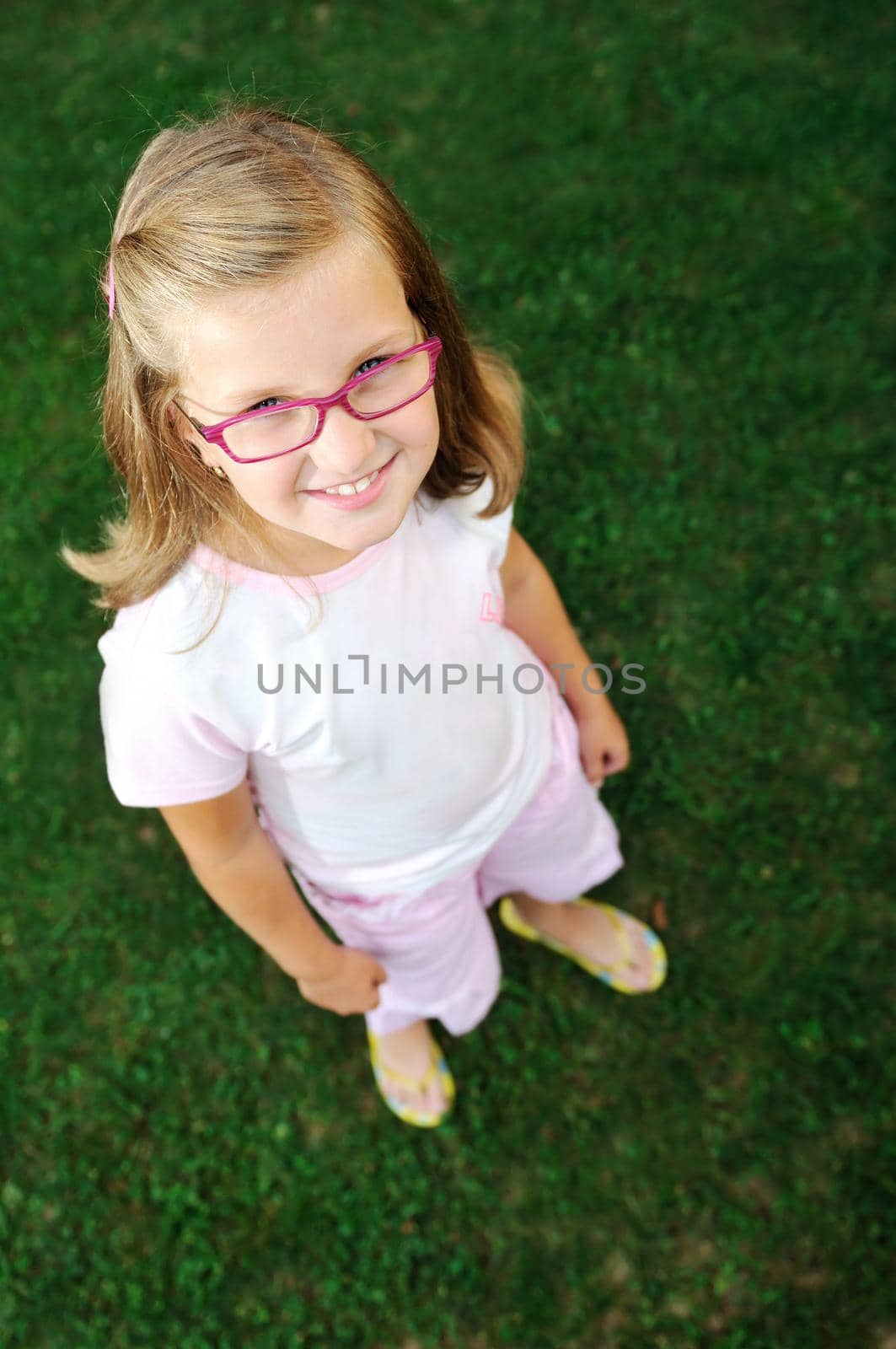 happy young girl children relax lie and have fun on grass with flower