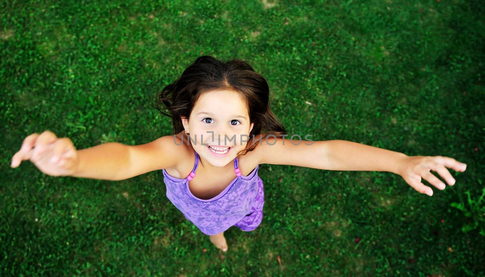 happy young girl children relax lie and have fun on grass with flower