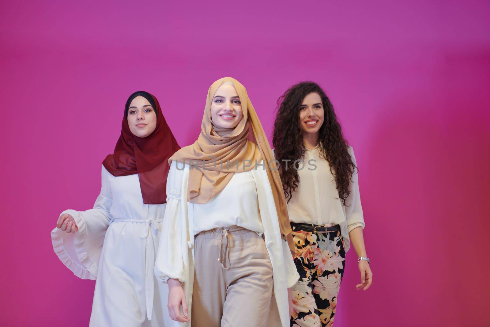 muslim women in fashionable dress isolated on pink by dotshock