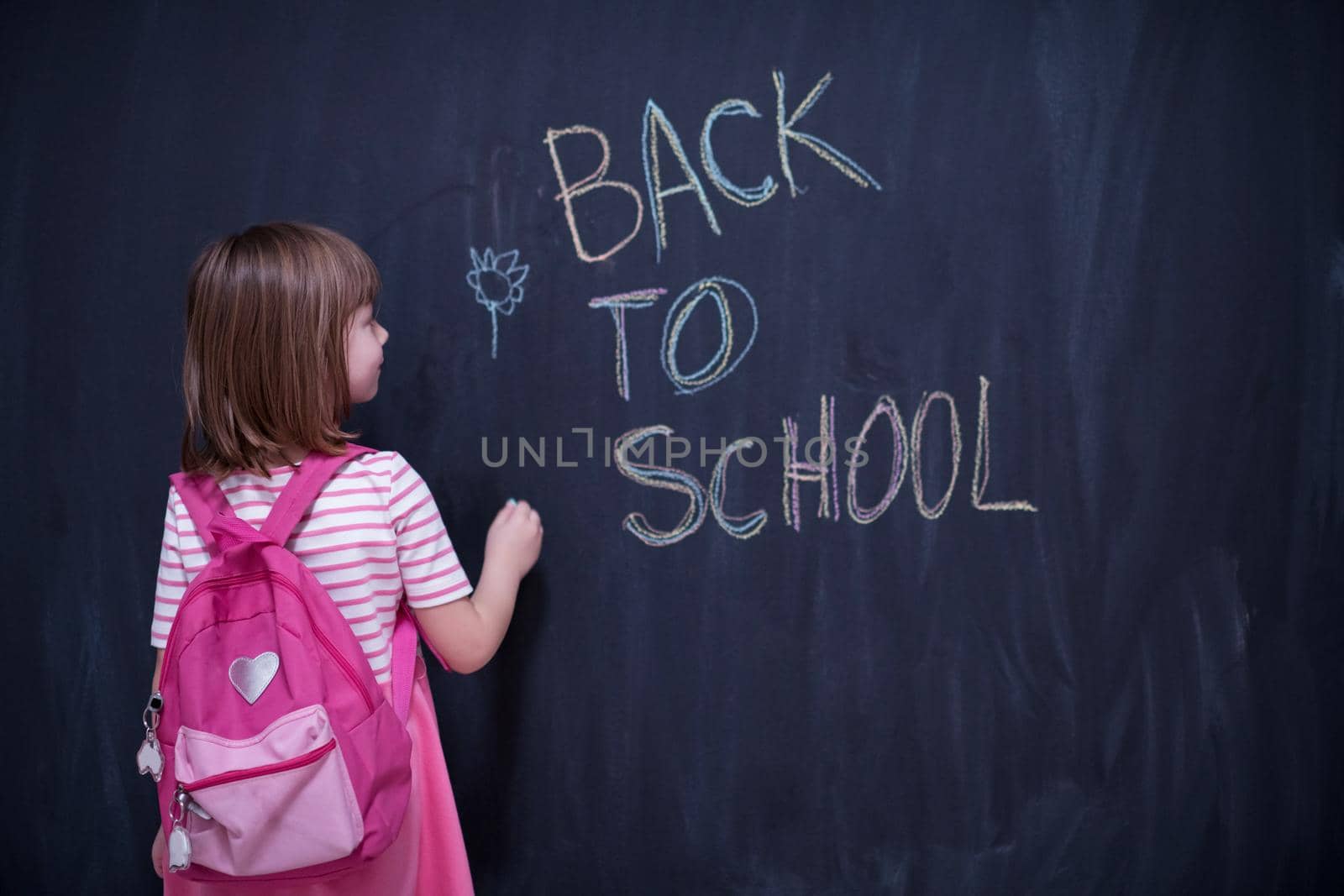 school girl child with backpack writing  chalkboard by dotshock