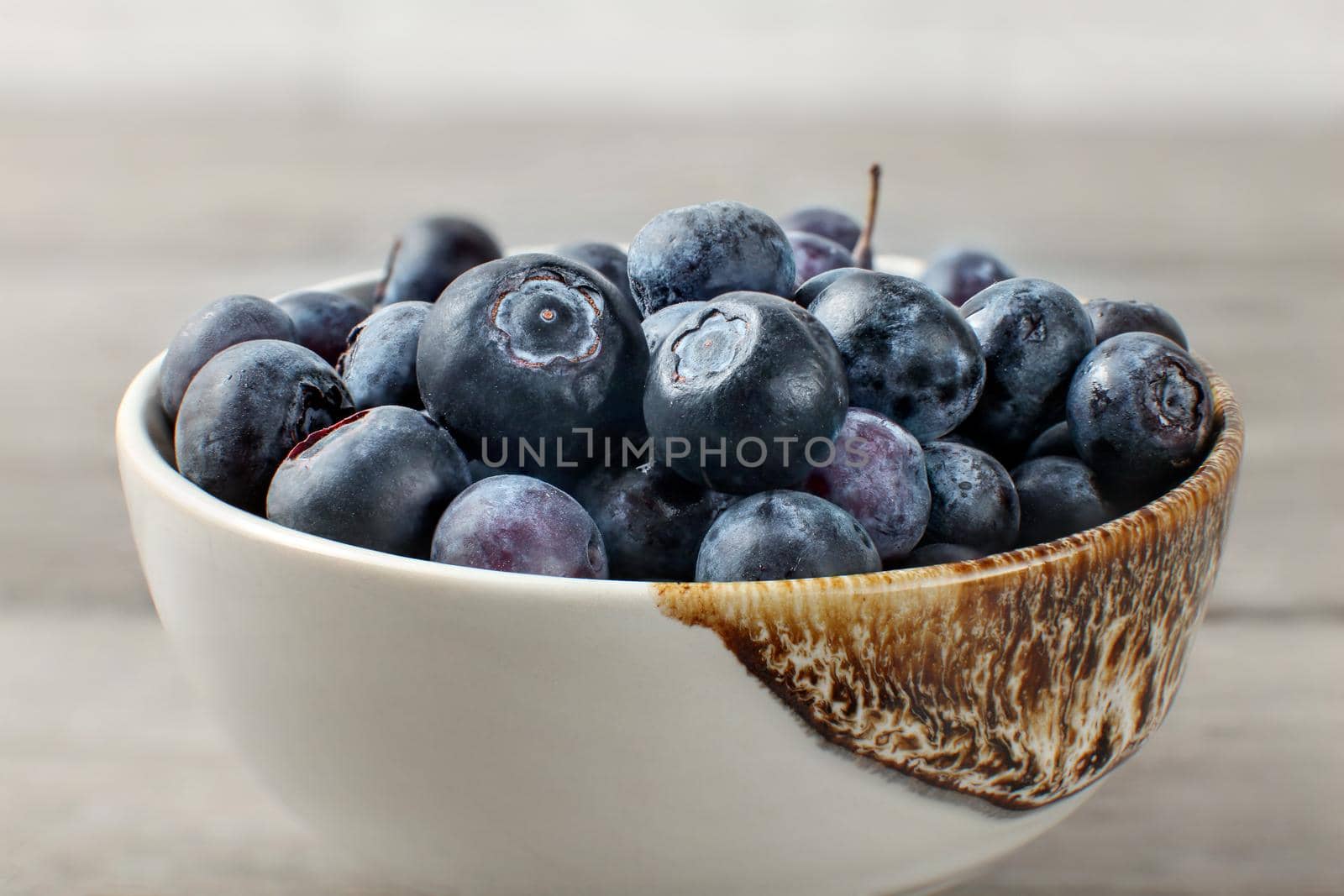 Detail on blueberries in small ceramic bowl.