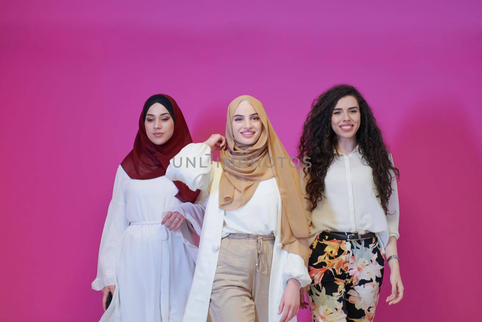 muslim women in fashionable dress isolated on pink by dotshock