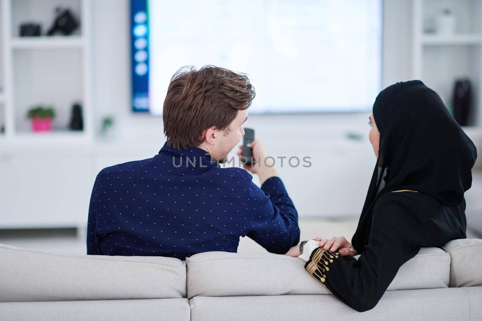 young muslim couple watching TV together by dotshock
