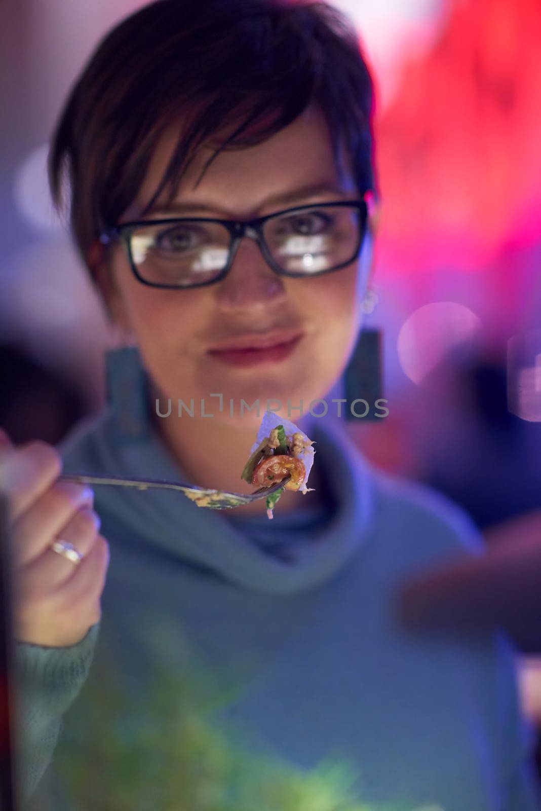 woman eating tasty dinner in modern restaurant by dotshock