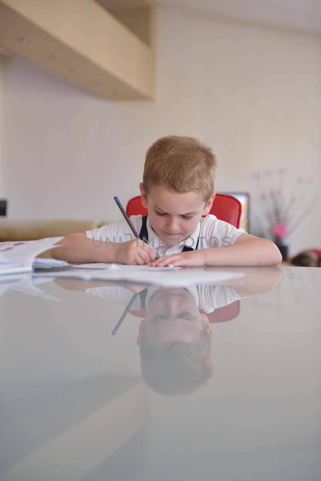 young mom woman doing home work with elementary school grade boy at home in kitchen