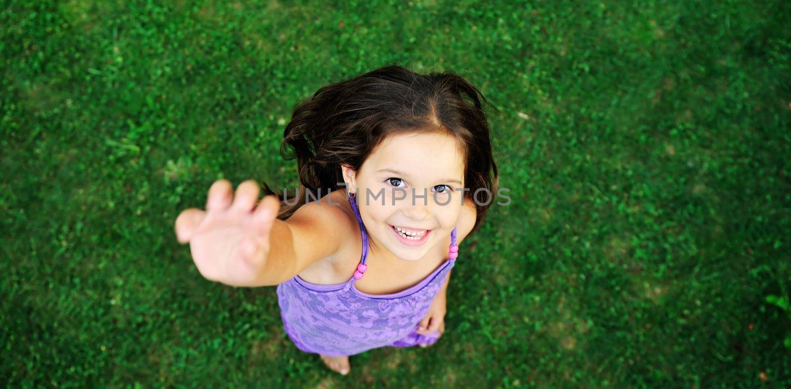 happy young girl children relax lie and have fun on grass with flower