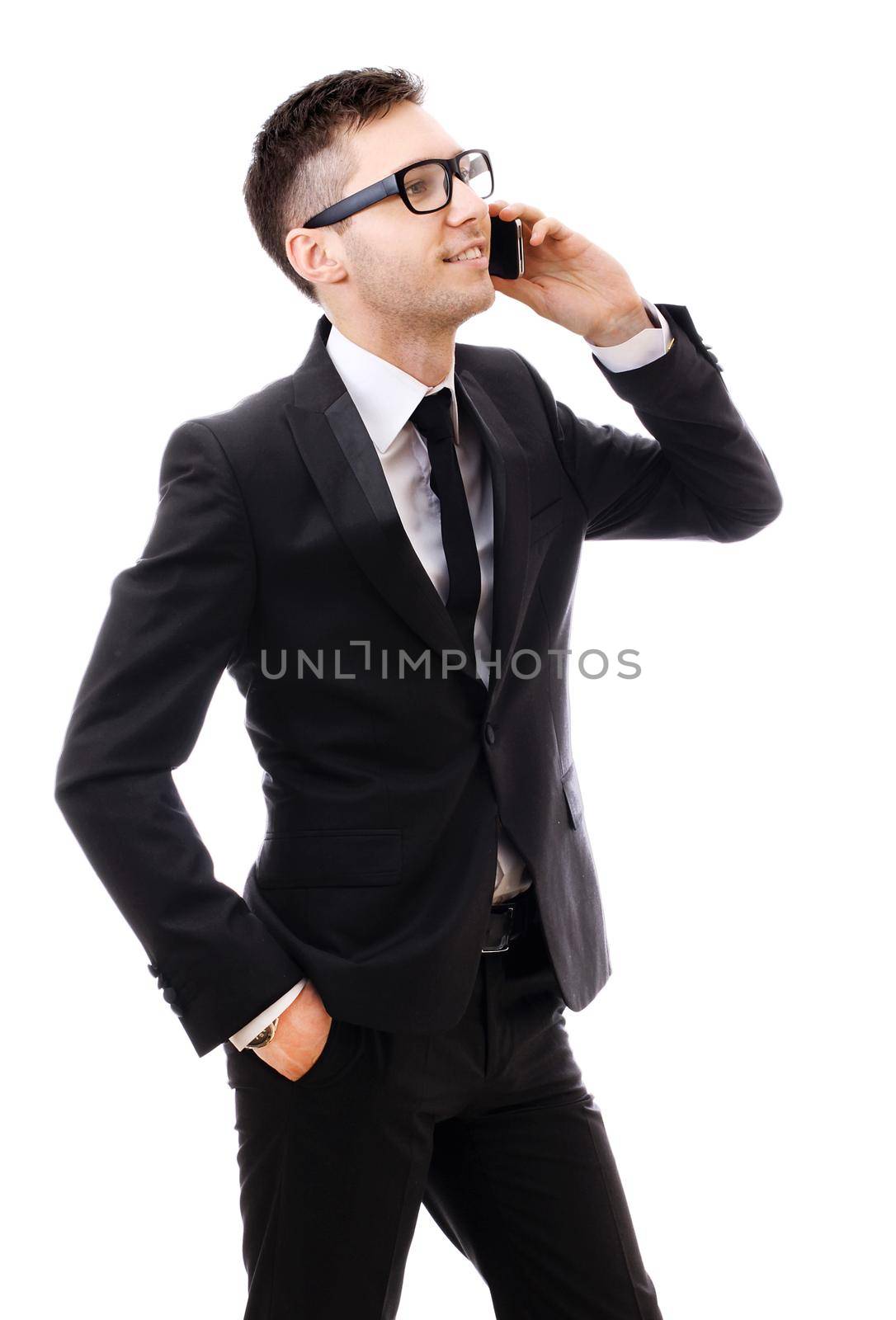 Businessman in suit with mobile phone smiling. Sure he gets good news. Isolated on white.