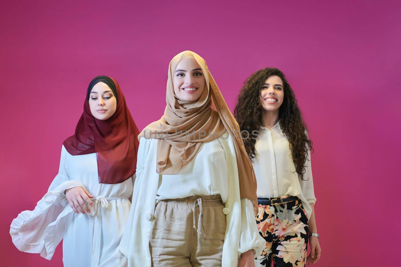 Young muslim women posing on pink background by dotshock