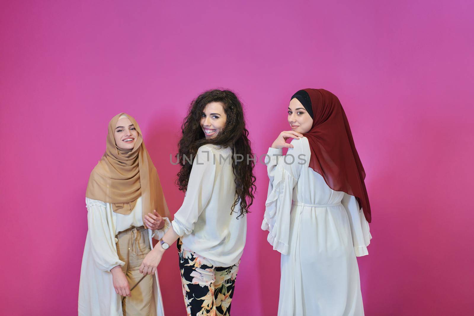 Young muslim women posing on pink background by dotshock