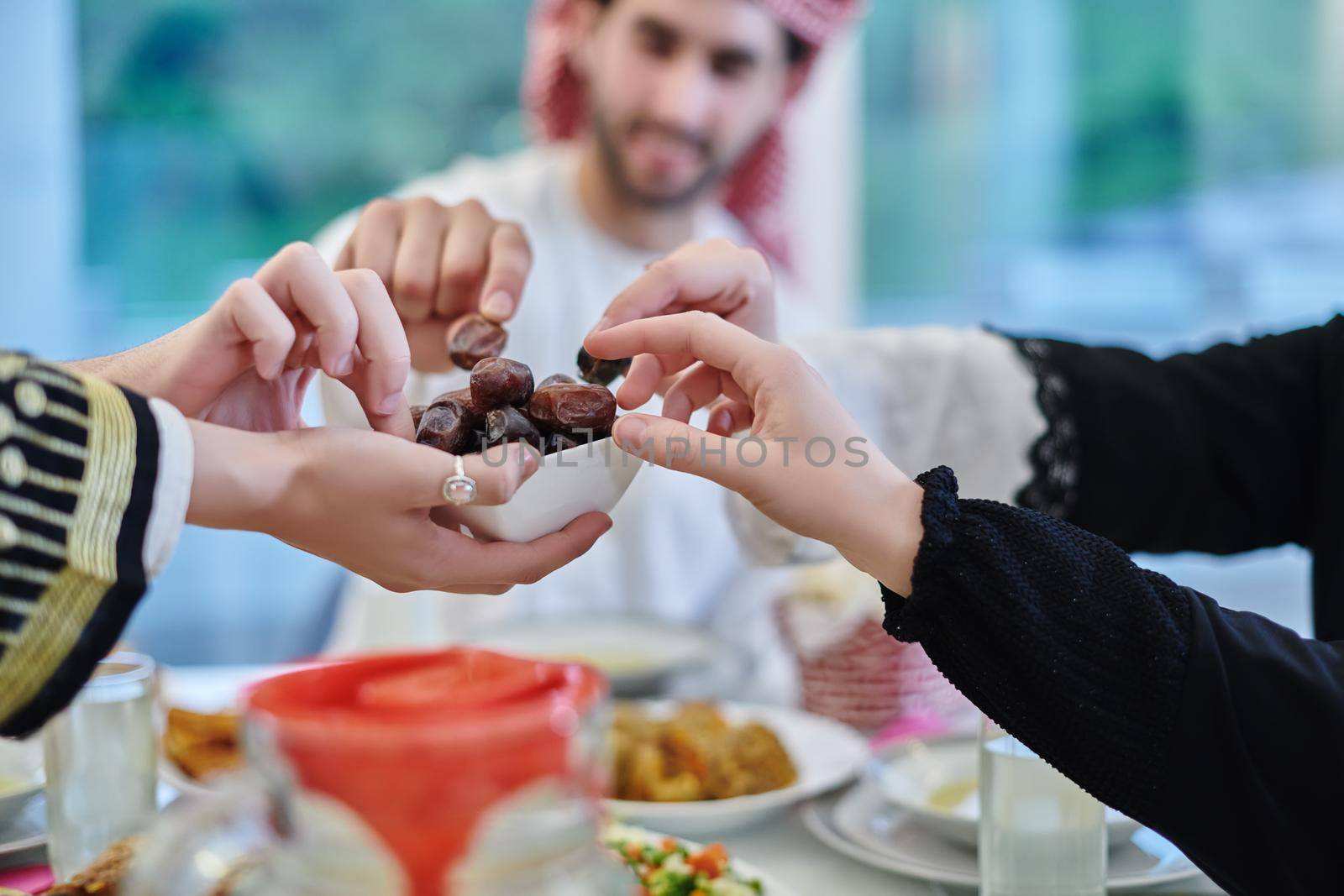 Muslim family having iftar together during Ramadan. Arabian people gathering for traditional dinner during fasting month. Dates sharing to break fasting