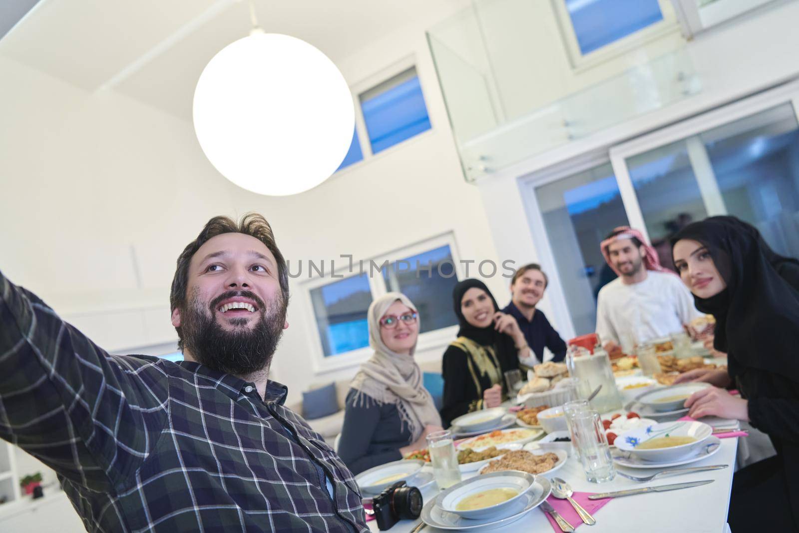 Muslim family taking selfie while having iftar together during Ramadan. Arabian people gathering for traditional dinner during fasting month.
