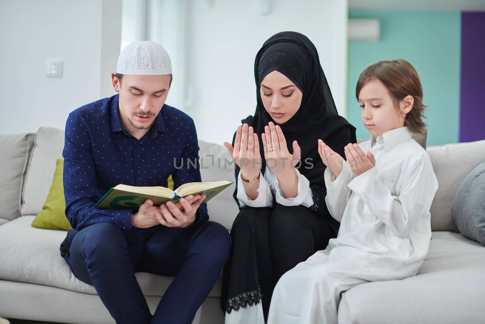 Young muslim family reading Quran during Ramadan by dotshock
