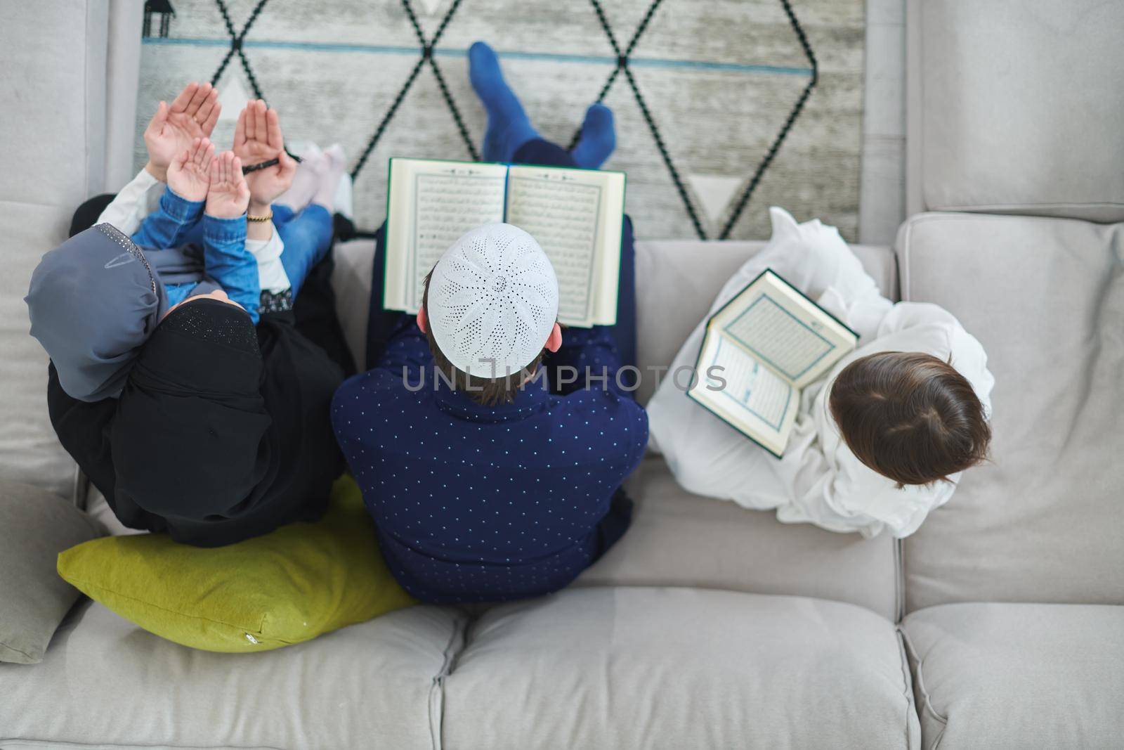 Top view of young muslim family reading Quran during Ramadan by dotshock
