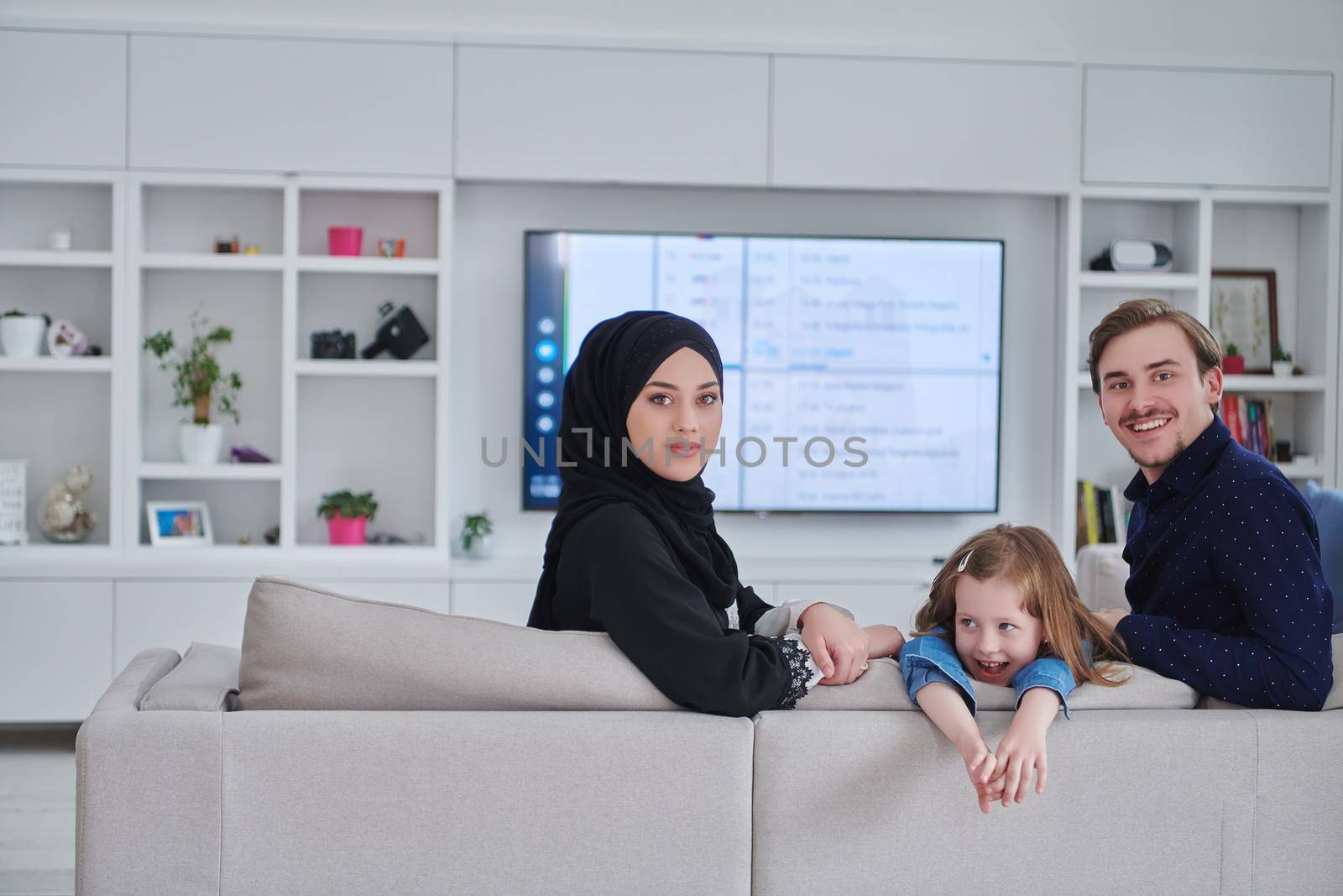Happy Muslim family spending time together in modern home by dotshock