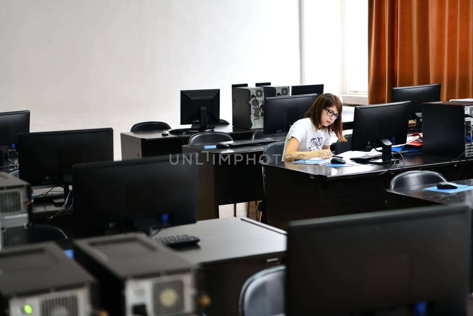 Only one female student in computers and  technology classroom working and learning concept of persistence