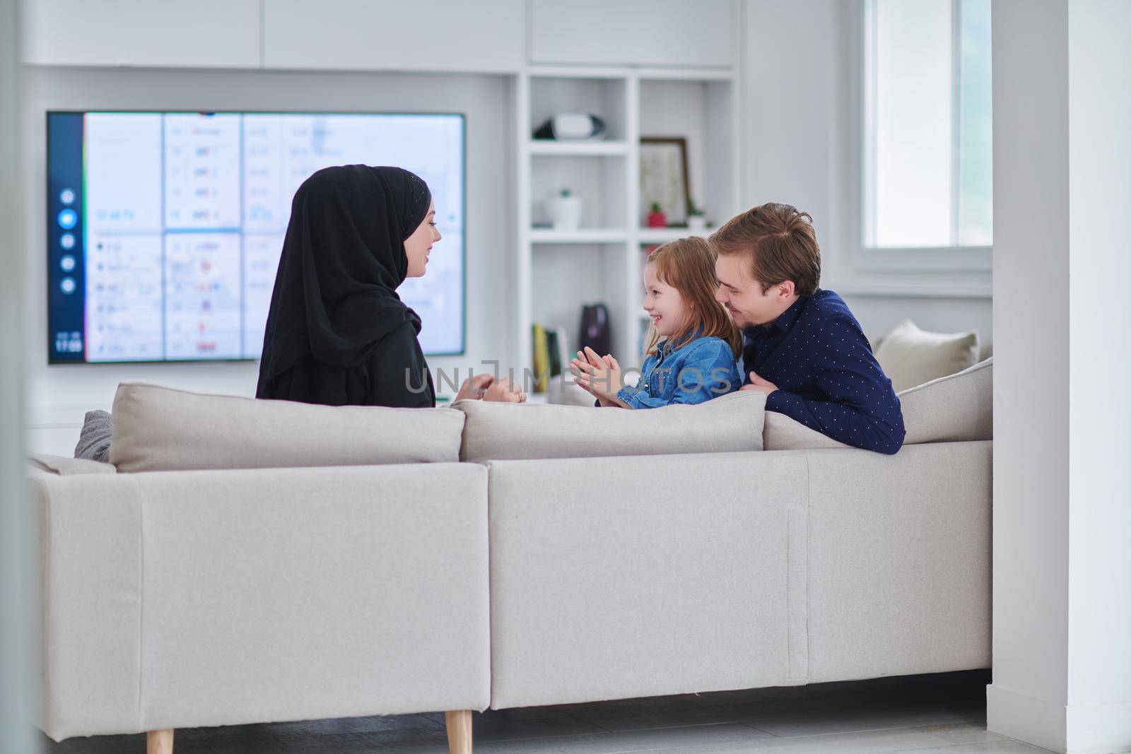 Happy Muslim family spending time together in modern home by dotshock