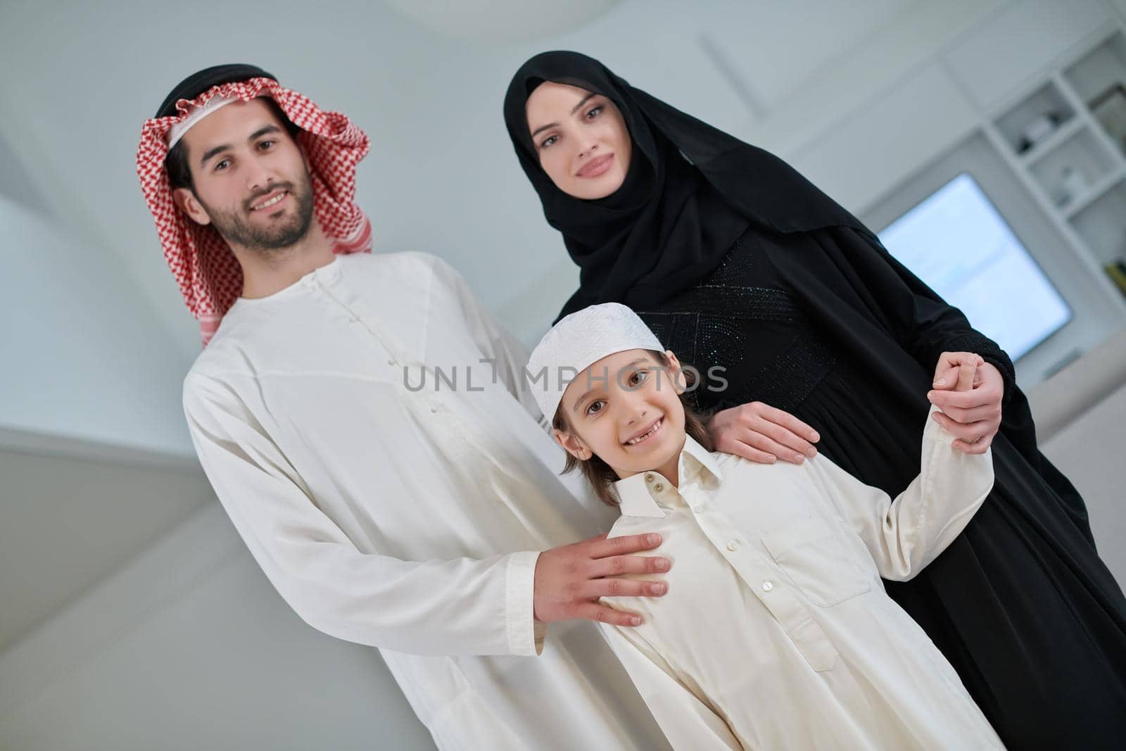 Portrait of young arabian muslim family wearing traditional clothes by dotshock