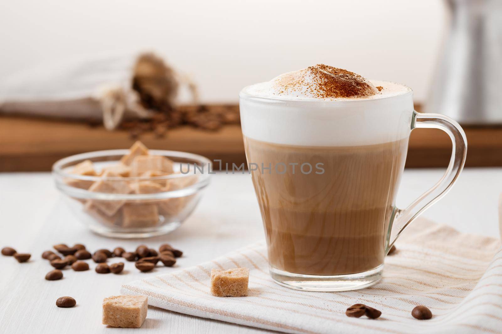 Latte coffee poured in layers with froth and a crispy chocolate top on a light kitchen table by galsand