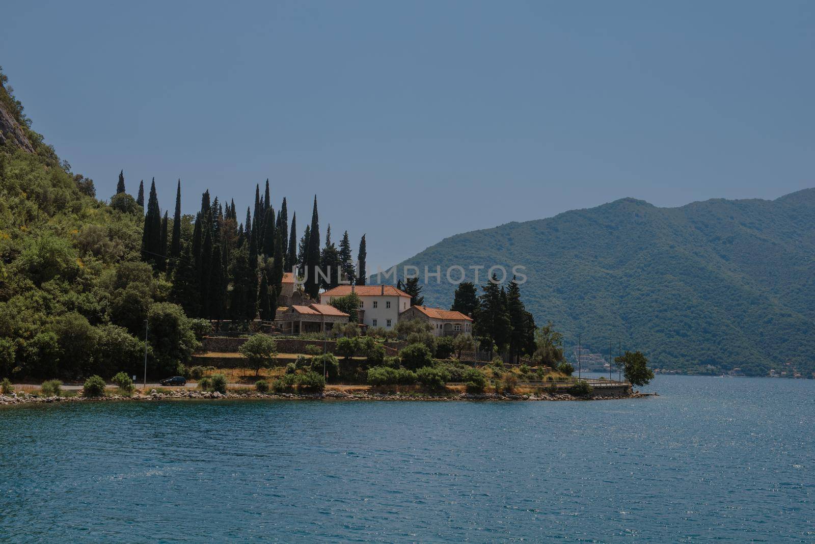 Blue boat in Bay of Kotor of Adriatic Sea, Montenegro. Beautiful view of the natural landscape. shore of Kotor. Scenic summer resort landscape. summer rest, vacation.