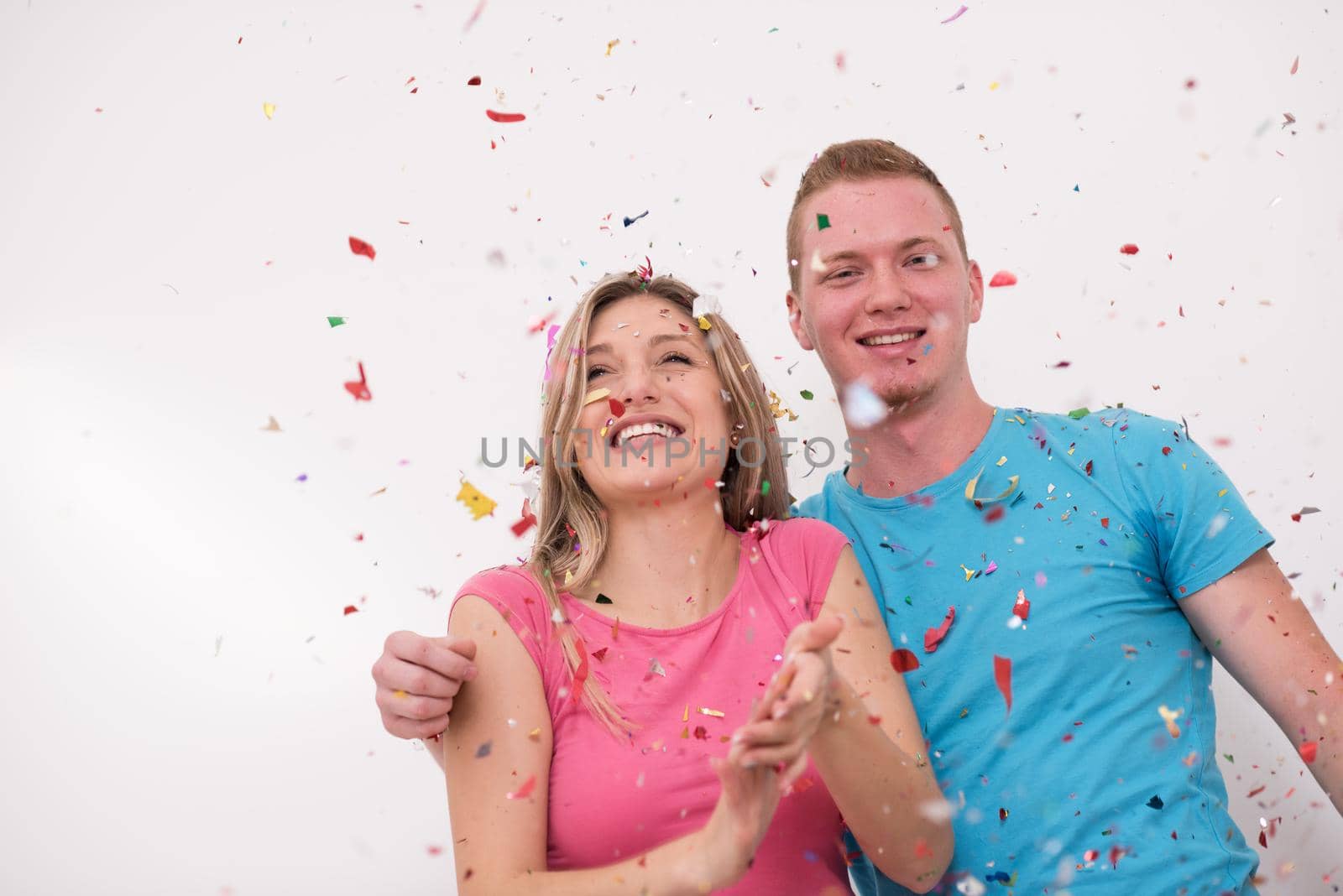 young romantic  couple in love  celebrating and blowing confetti decorations