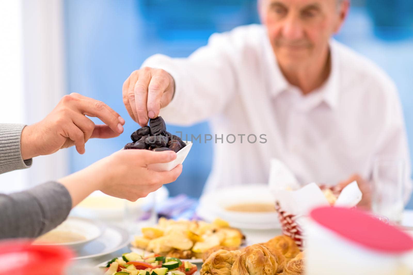modern multiethnic muslim family sharing a bowl of dates by dotshock