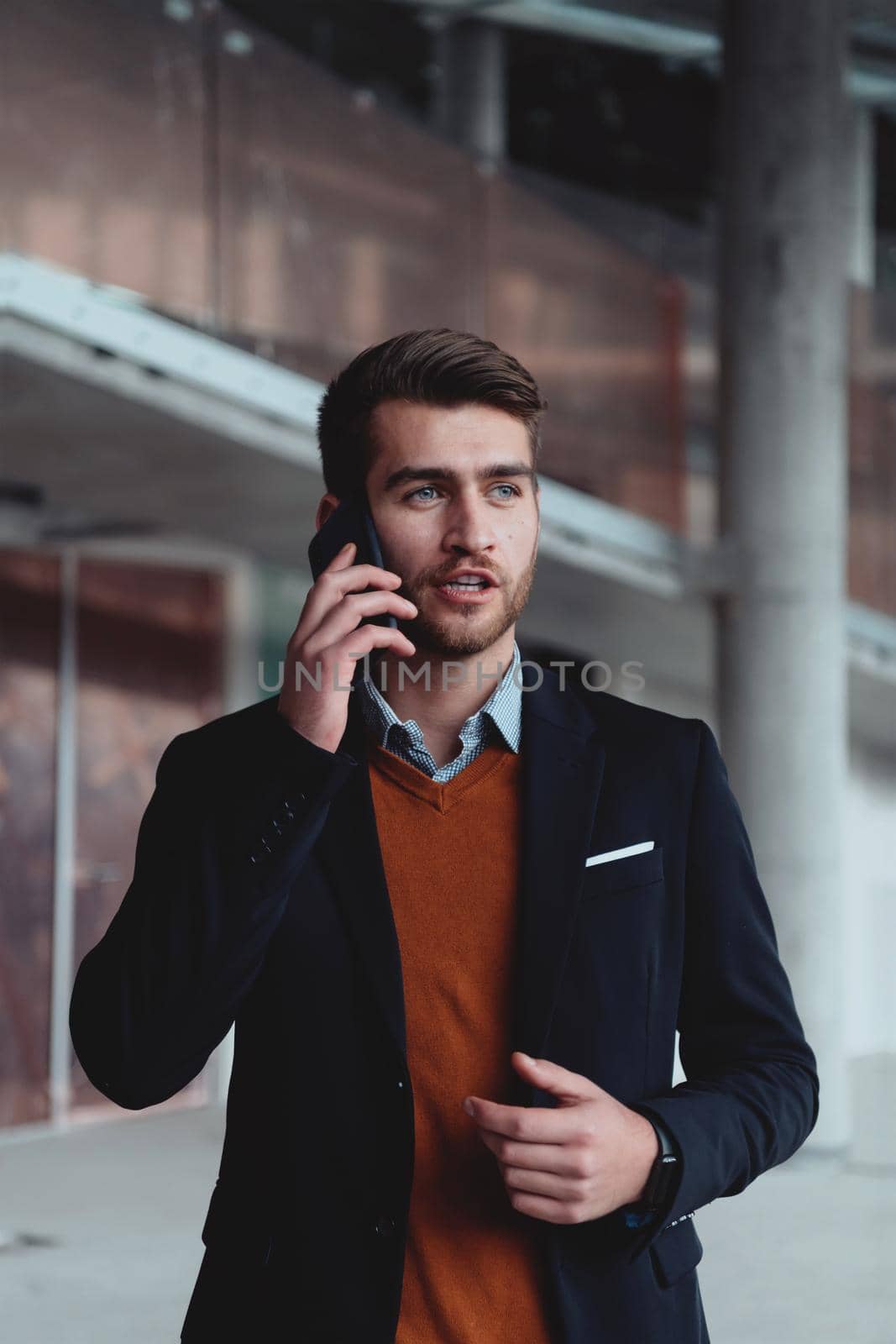 businessman architect expert using a smartphone while overseeing the construction site of a modern office building