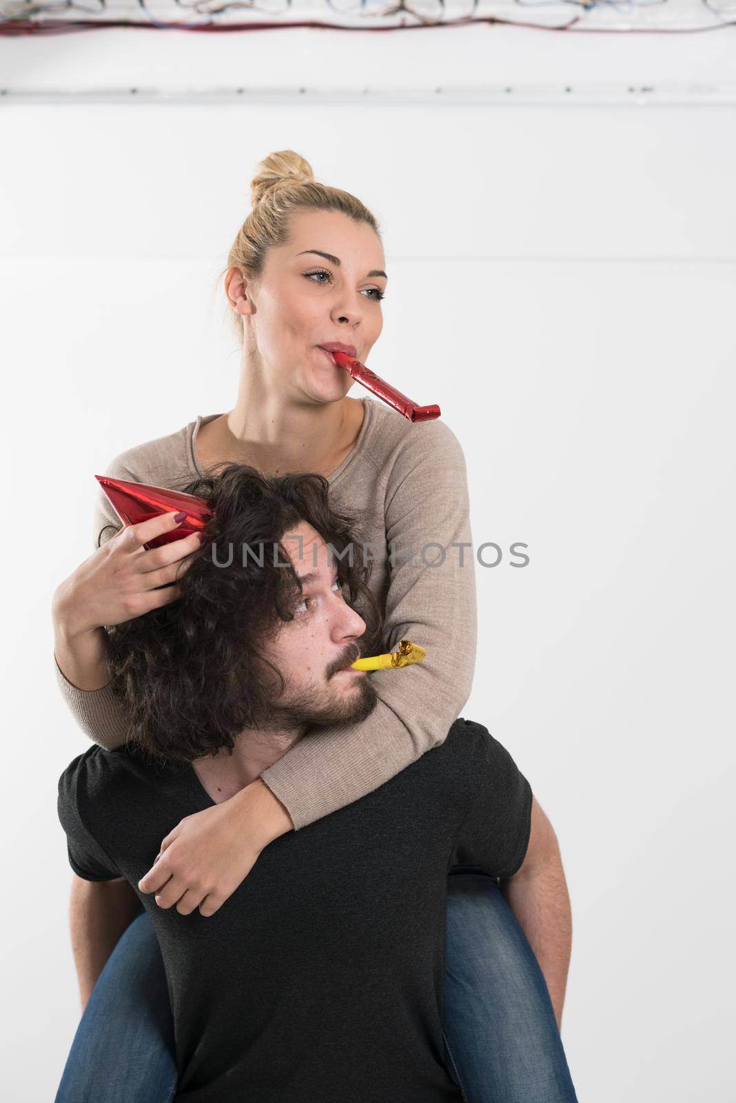 happy young romantic  couple in love  celebrating and blowing confetti decorations at new year and charismas  party