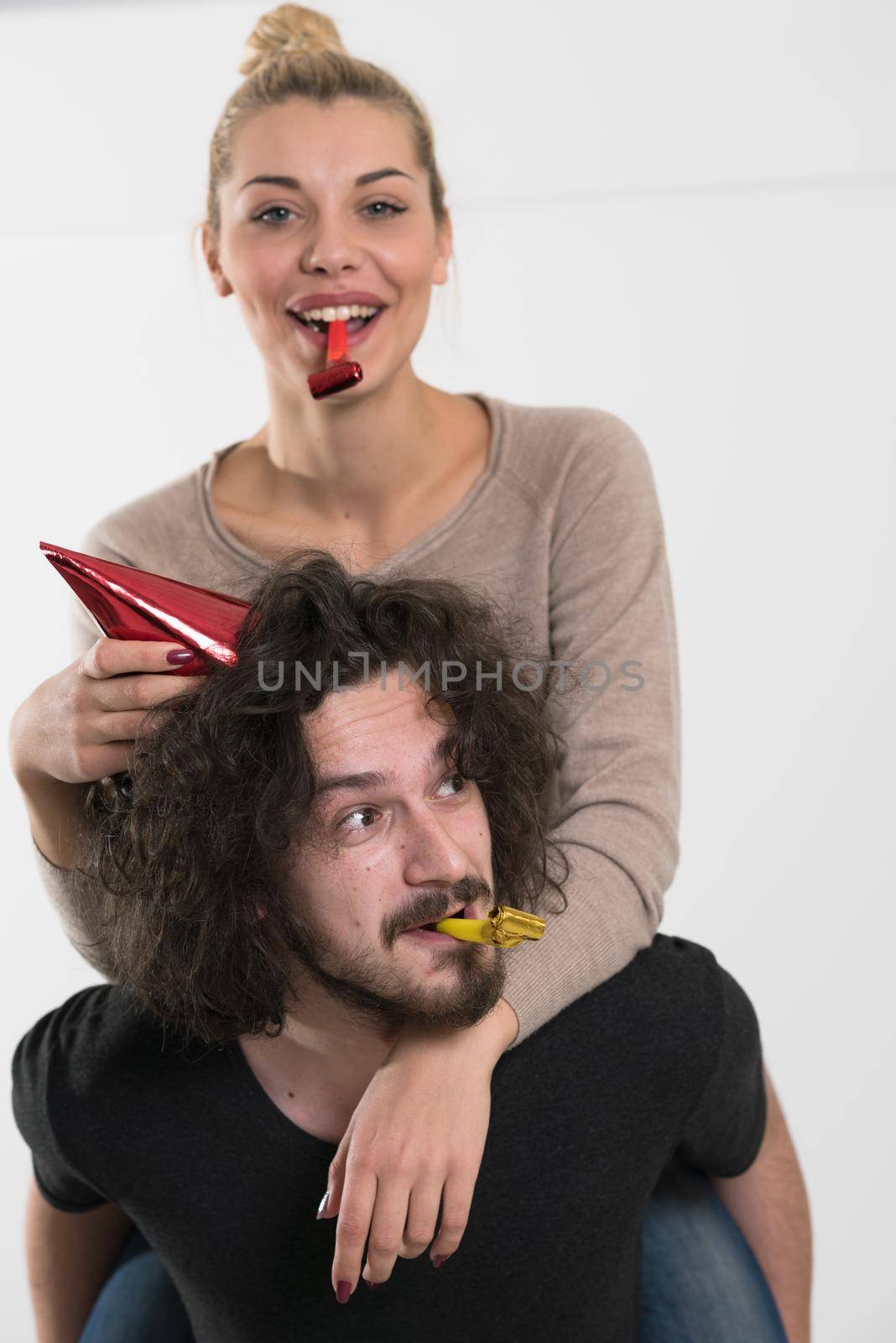 happy young romantic  couple in love  celebrating and blowing confetti decorations at new year and charismas  party