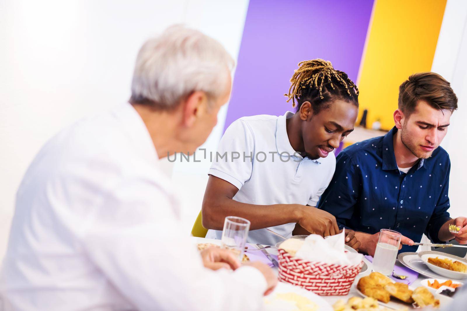 african american man enjoying iftar dinner together with modern multiethnic muslim family during a ramadan feast at home