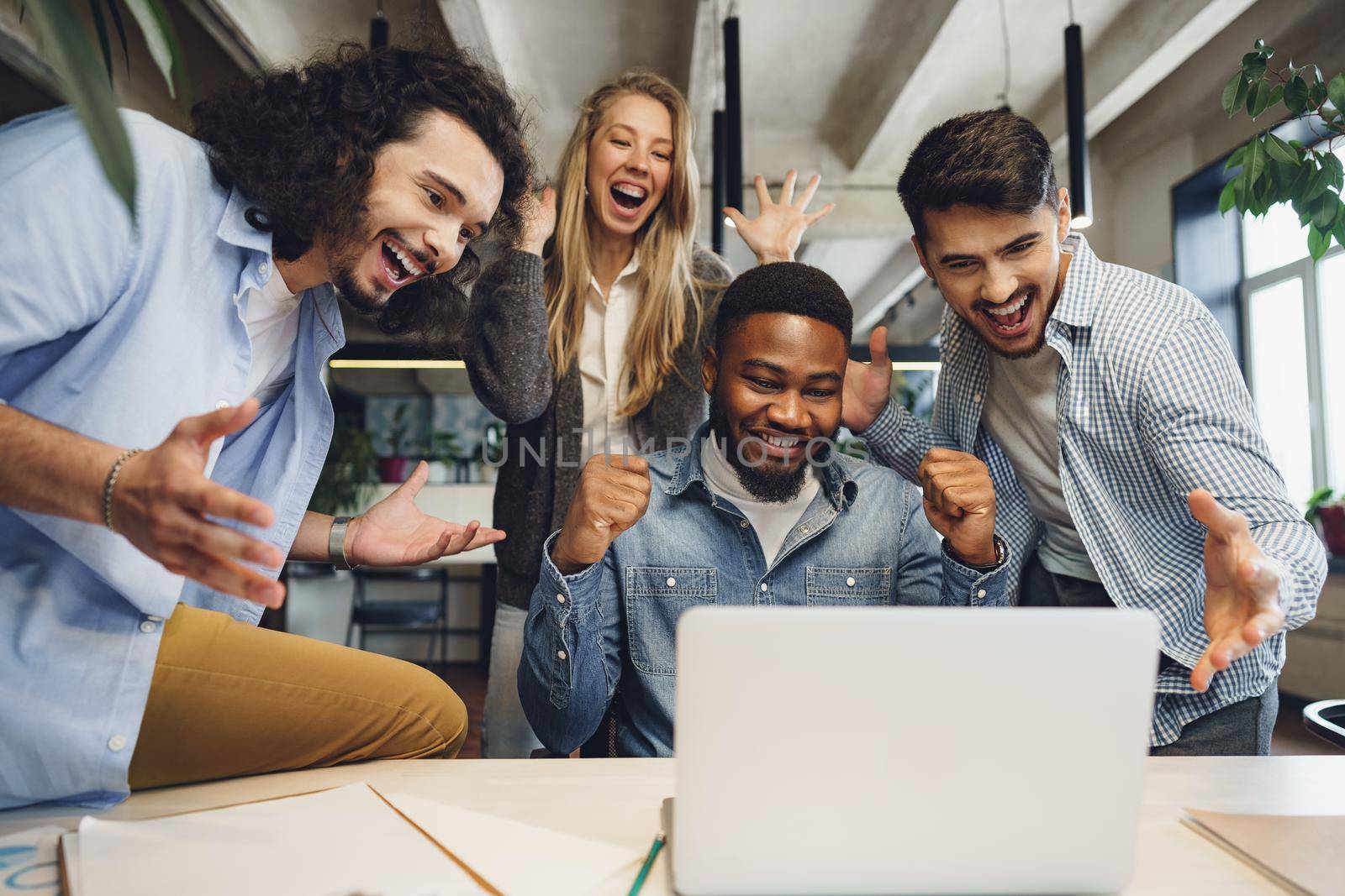 Happy overjoyed business team celebrate corporate victory in their office