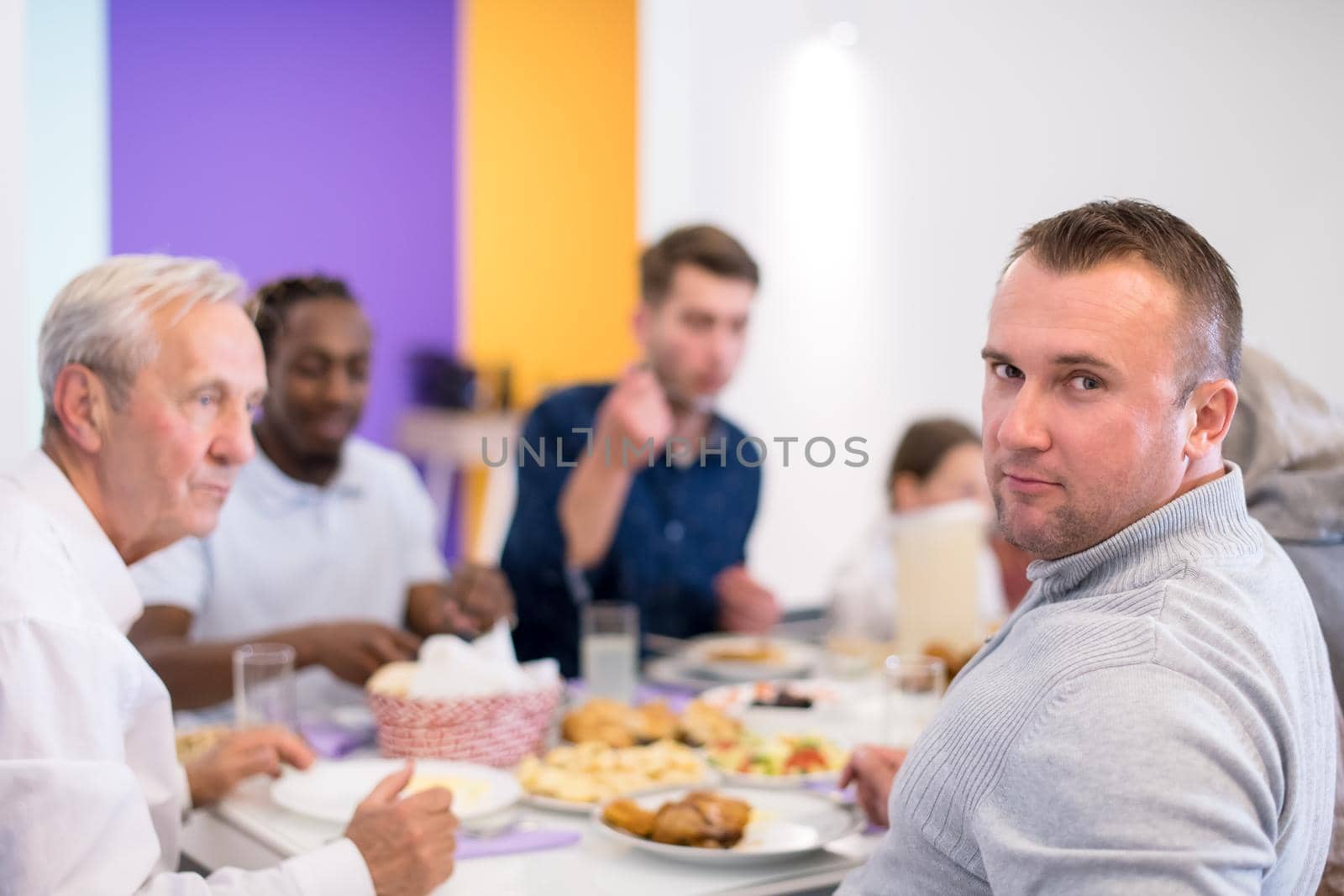 young muslim man enjoying iftar dinner with family by dotshock