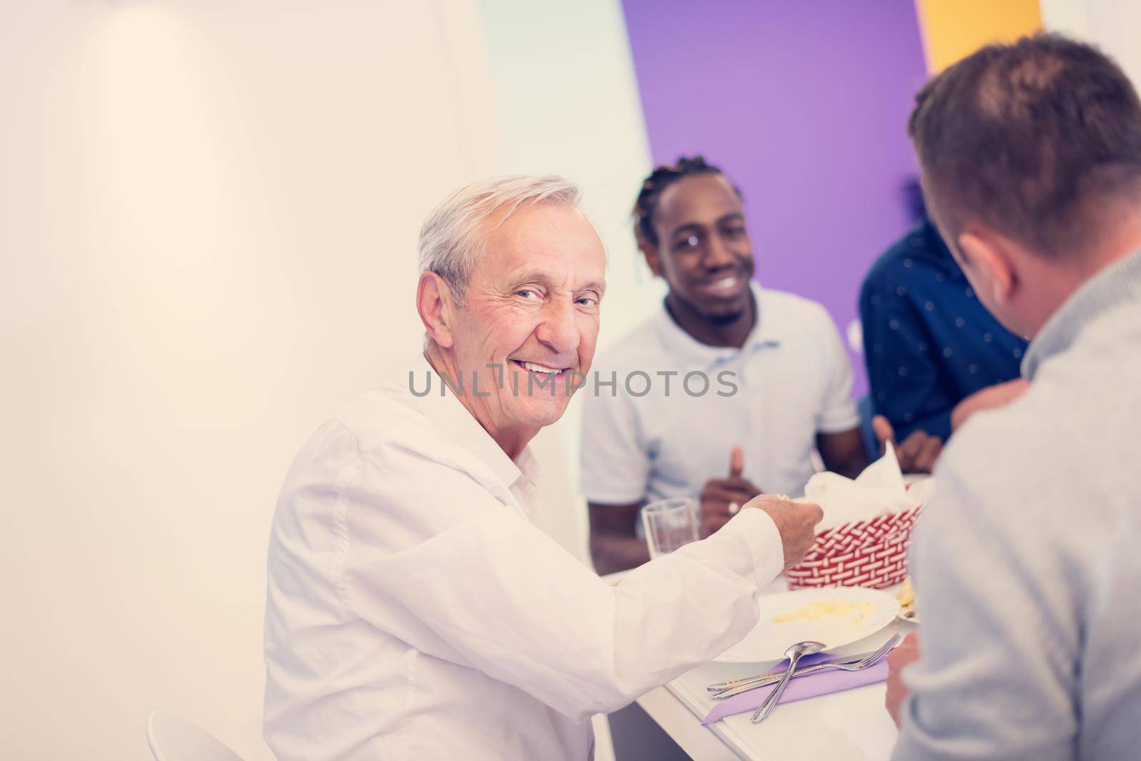 modern muslim grandfather enjoying iftar dinner with family by dotshock