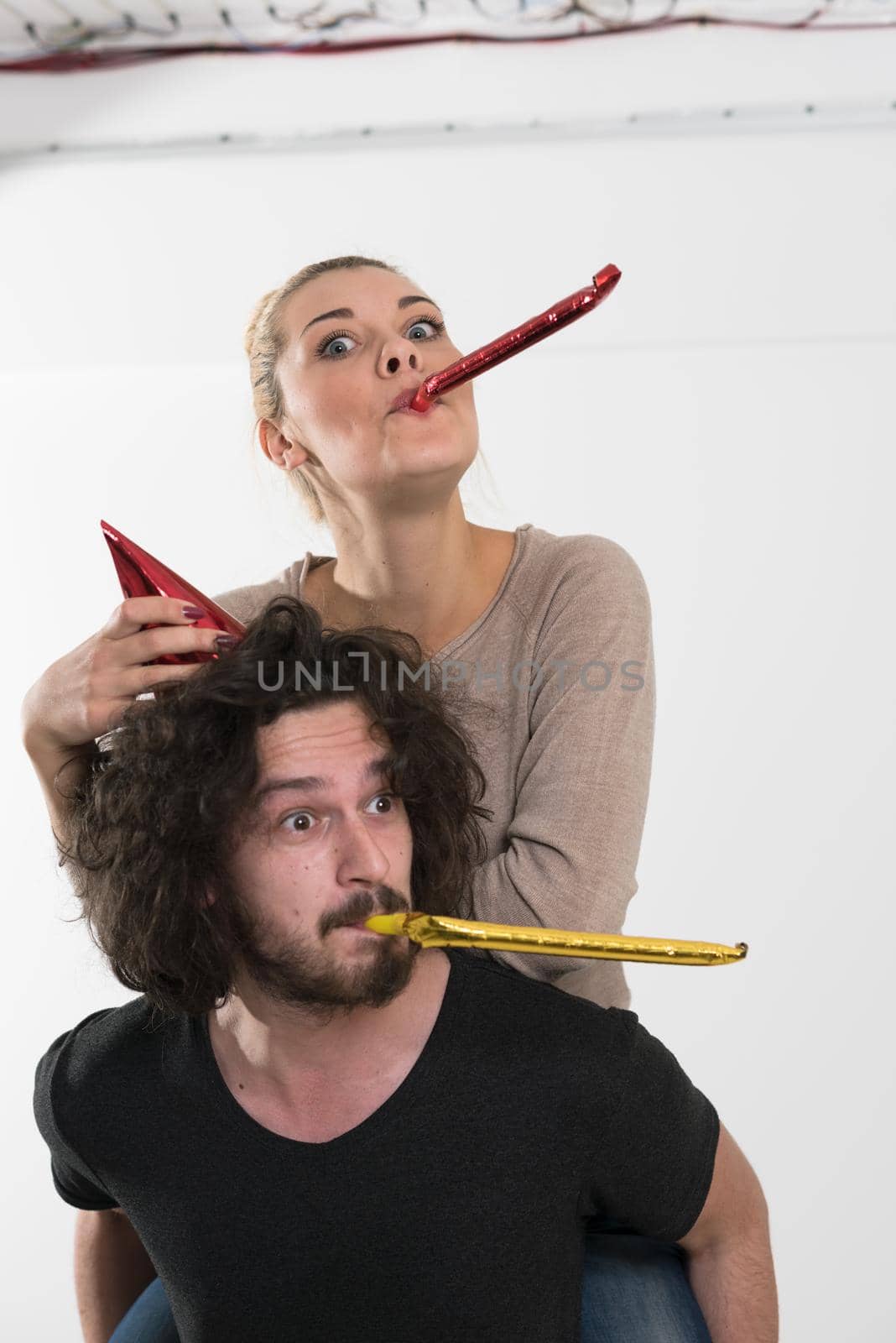 happy young romantic  couple in love  celebrating and blowing confetti decorations at new year and charismas  party