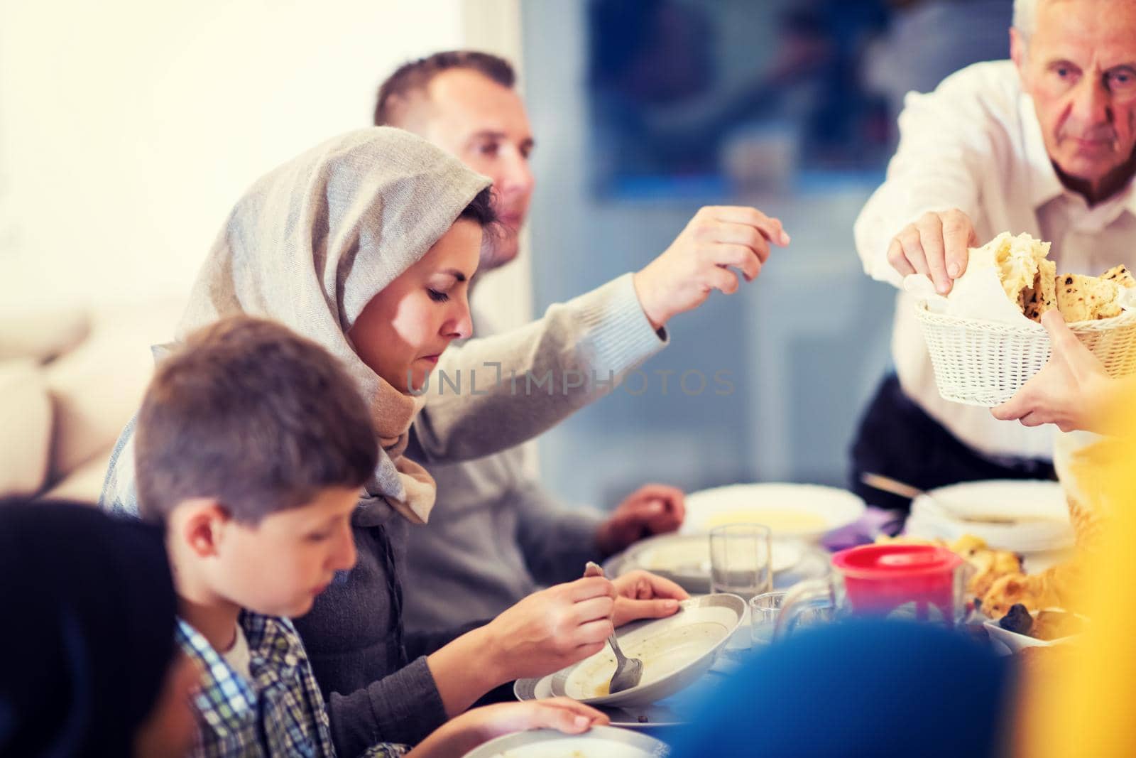 modern multiethnic muslim family enjoying eating iftar dinner together during a ramadan feast at home