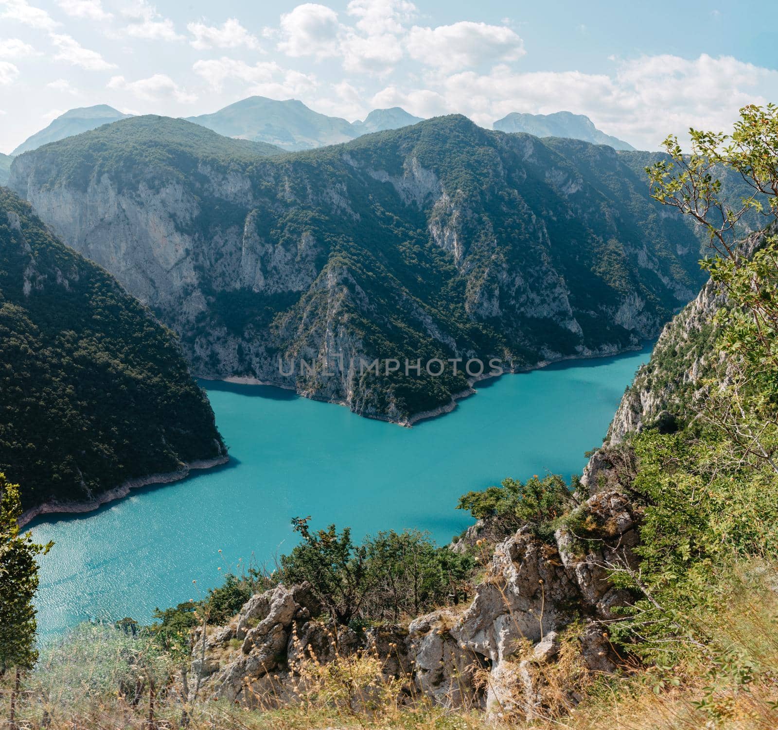 The concept of eco-tourism and active recreation. National Park. Mountain Emerald lake in the wooded mountains. Sunny day in autumn.