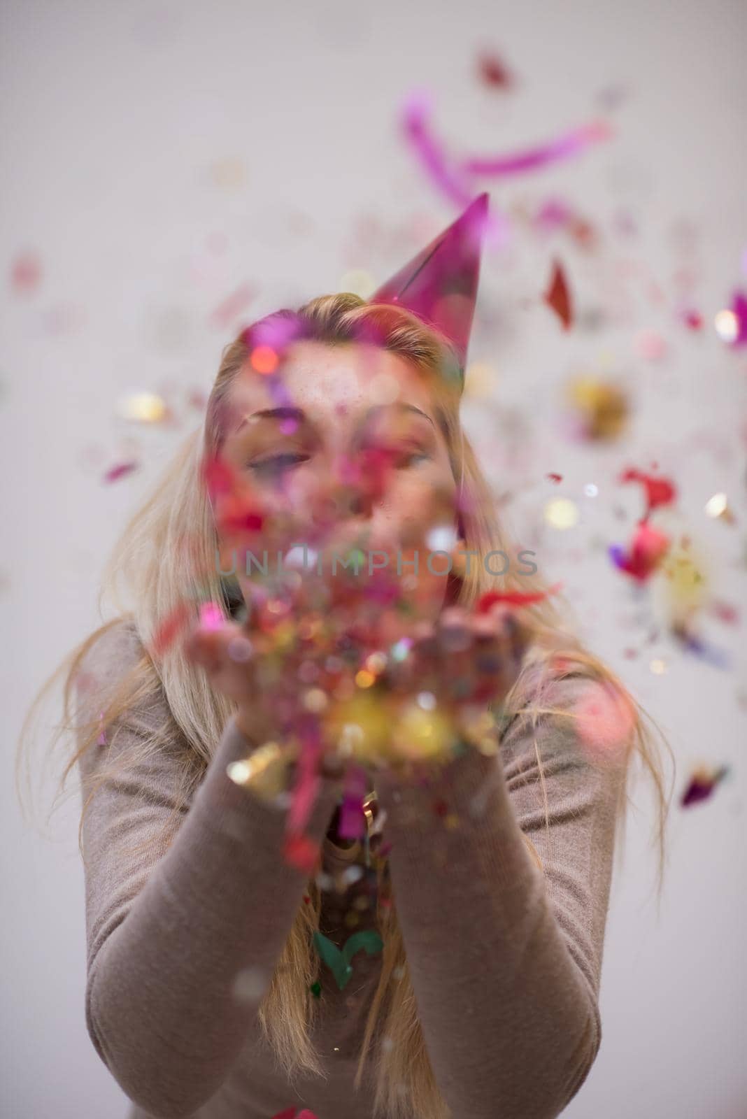 woman blowing confetti in the air by dotshock